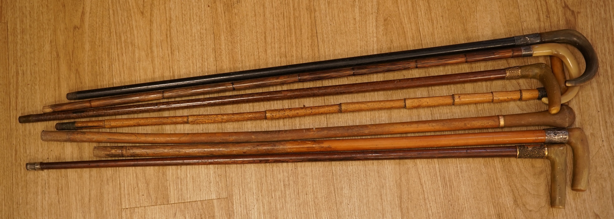 A collection of seven horn handles walking sticks some gold and white metal mounted